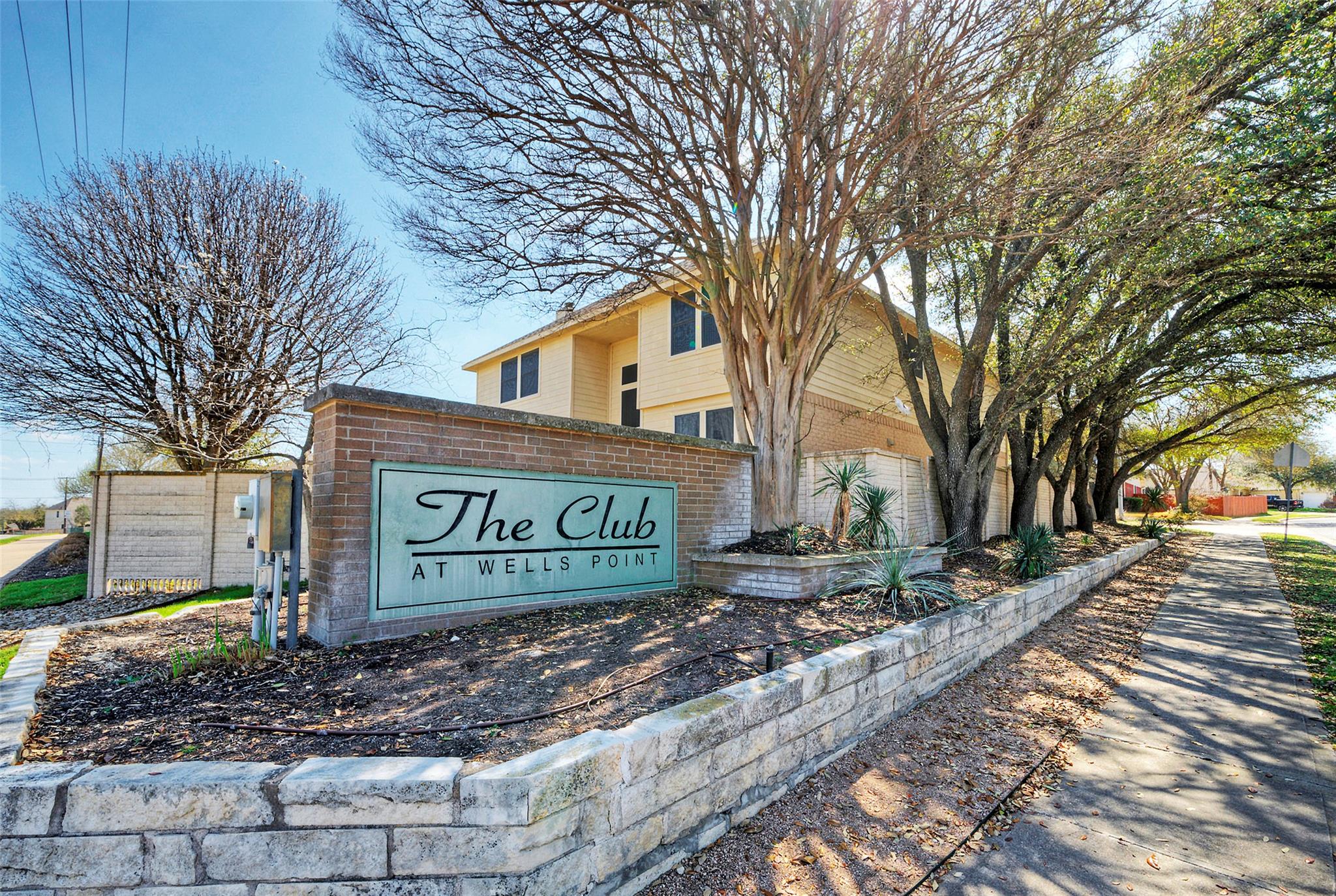 A welcoming stone and brick sign announces "The C