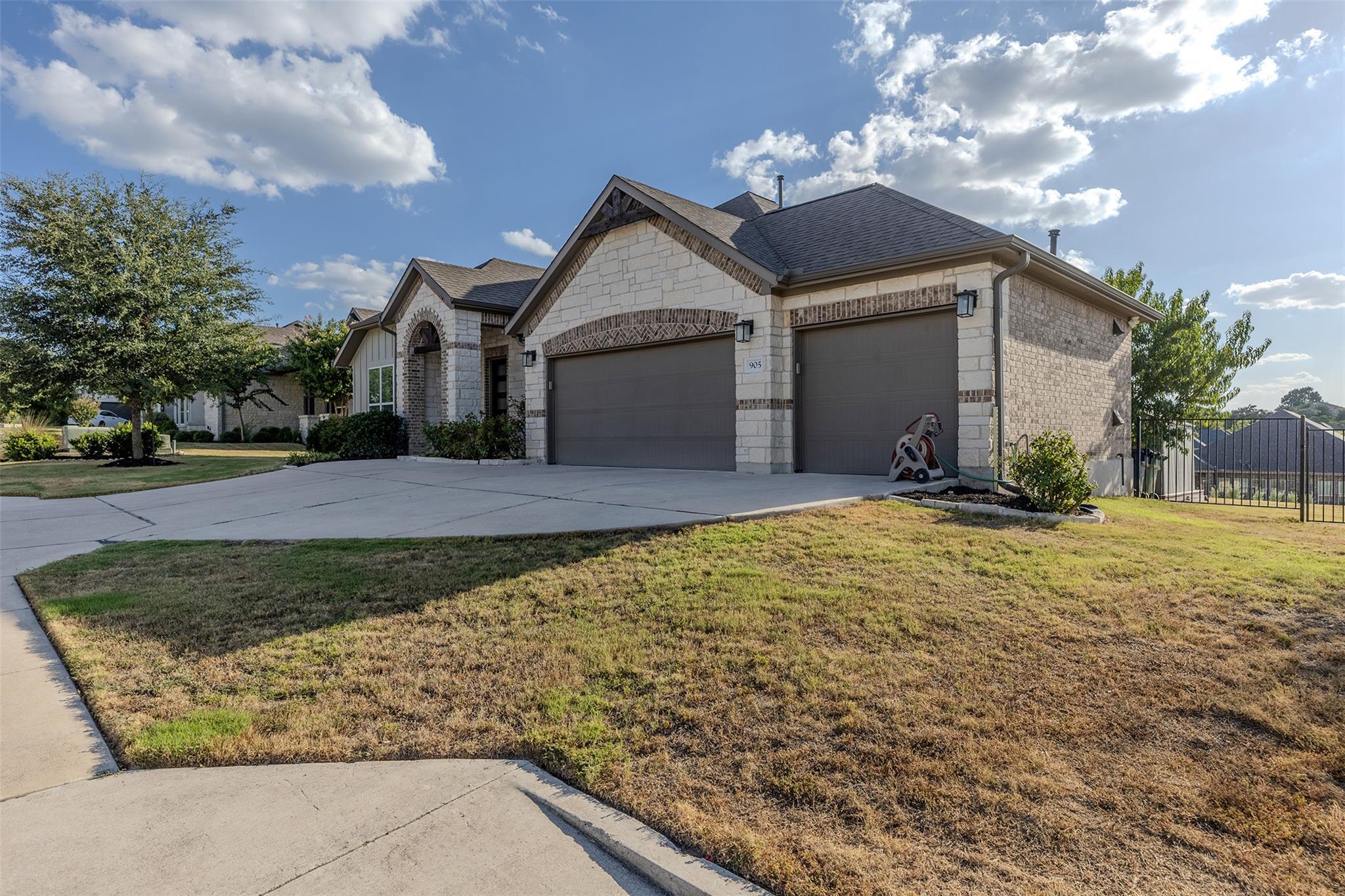 A spacious driveway leads to this stone-accented 