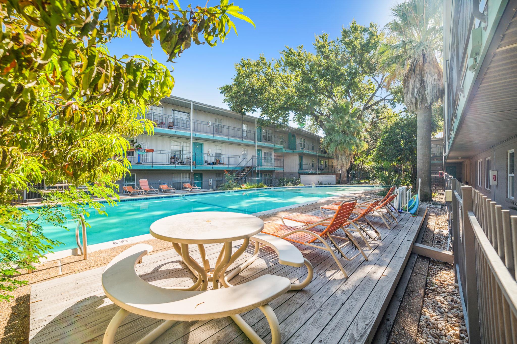 A refreshing pool awaits, bordered by a wooden de