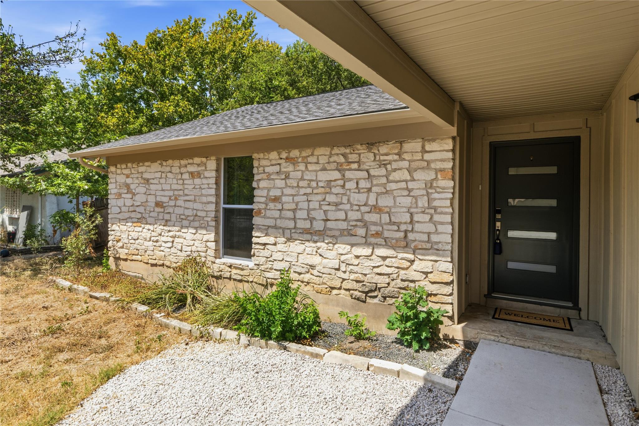 Natural stone masonry and a modern entry door cre