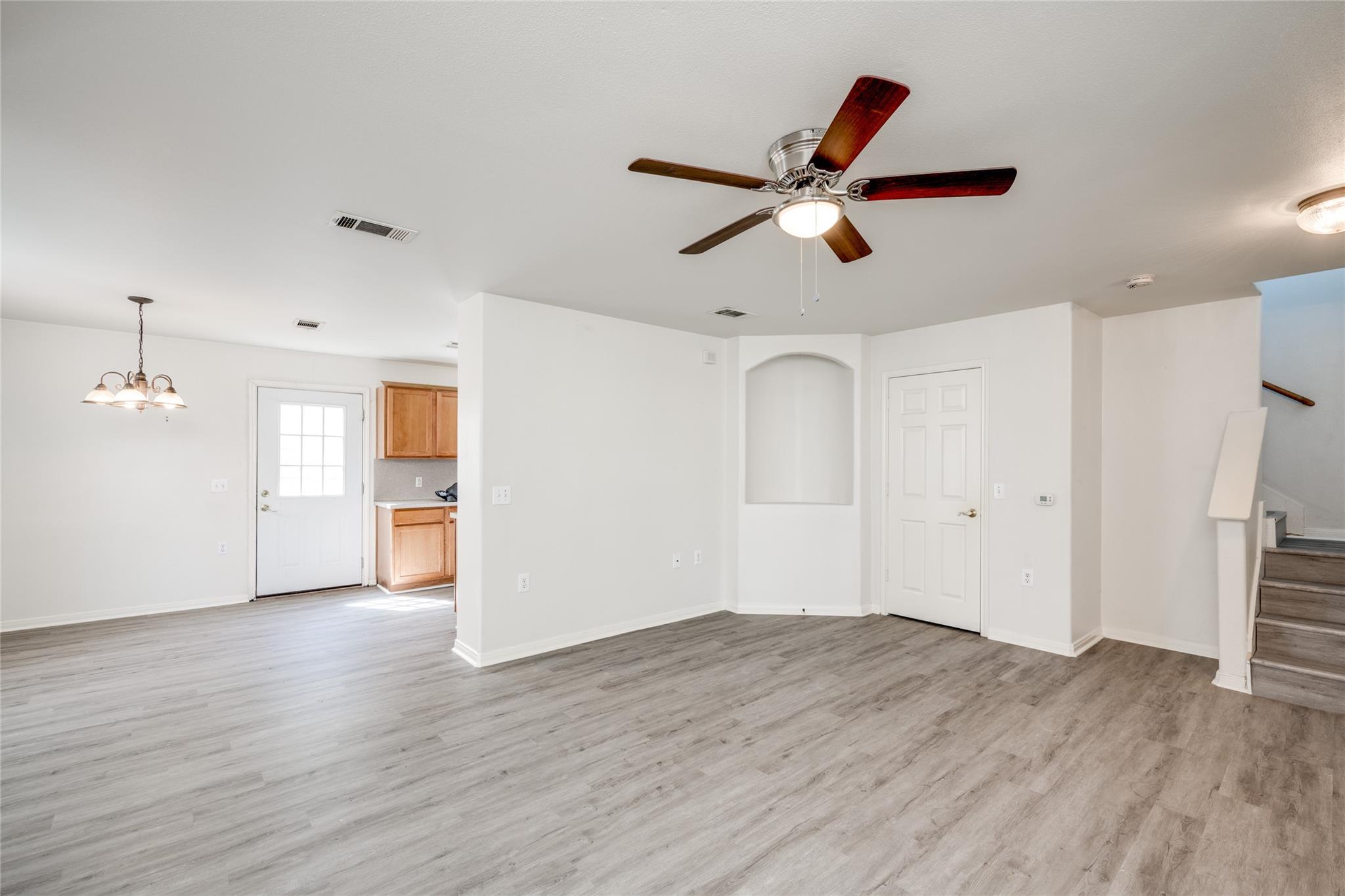 A well-lit interior space with fresh flooring, a 