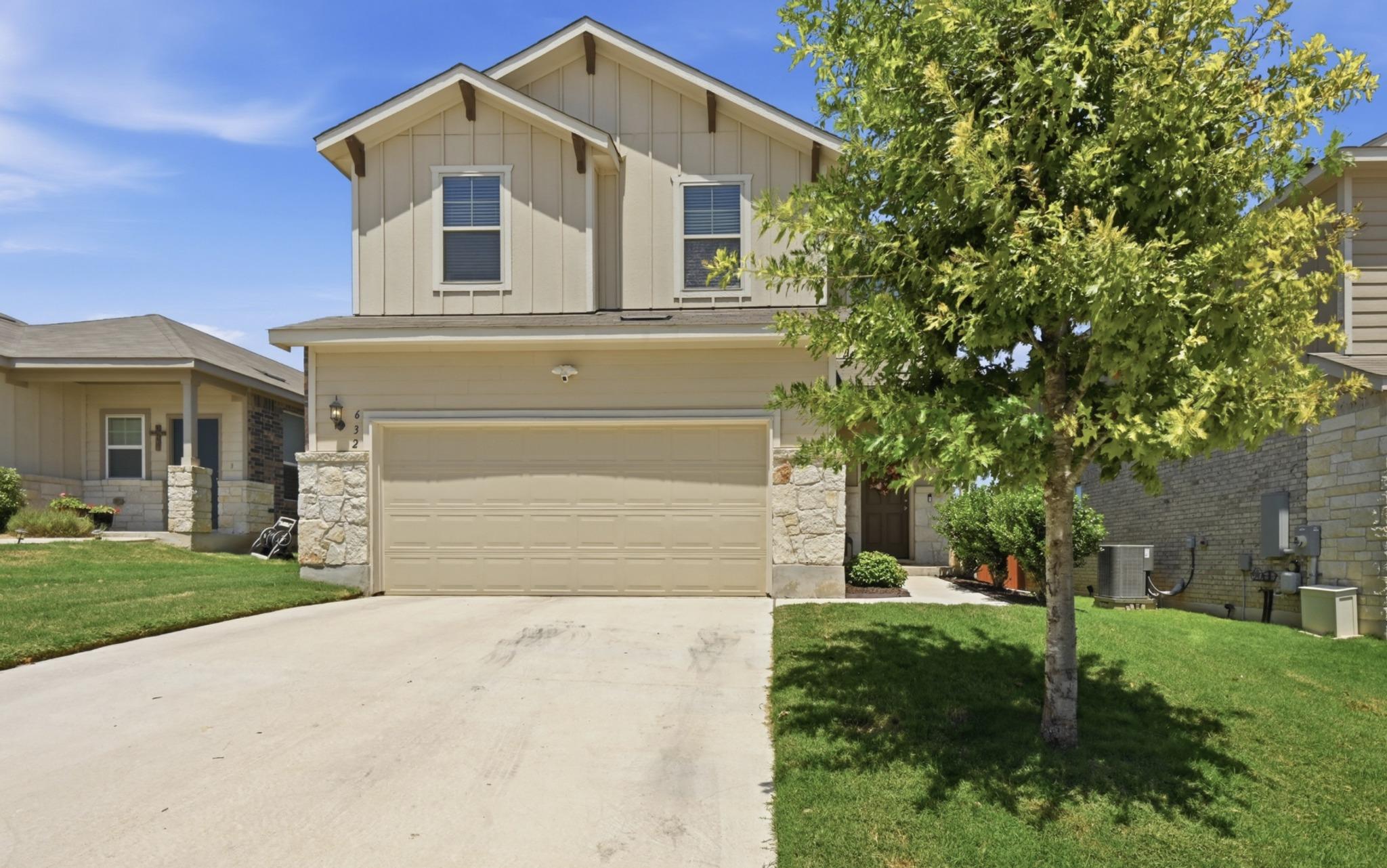 A welcoming facade with a concrete driveway leads