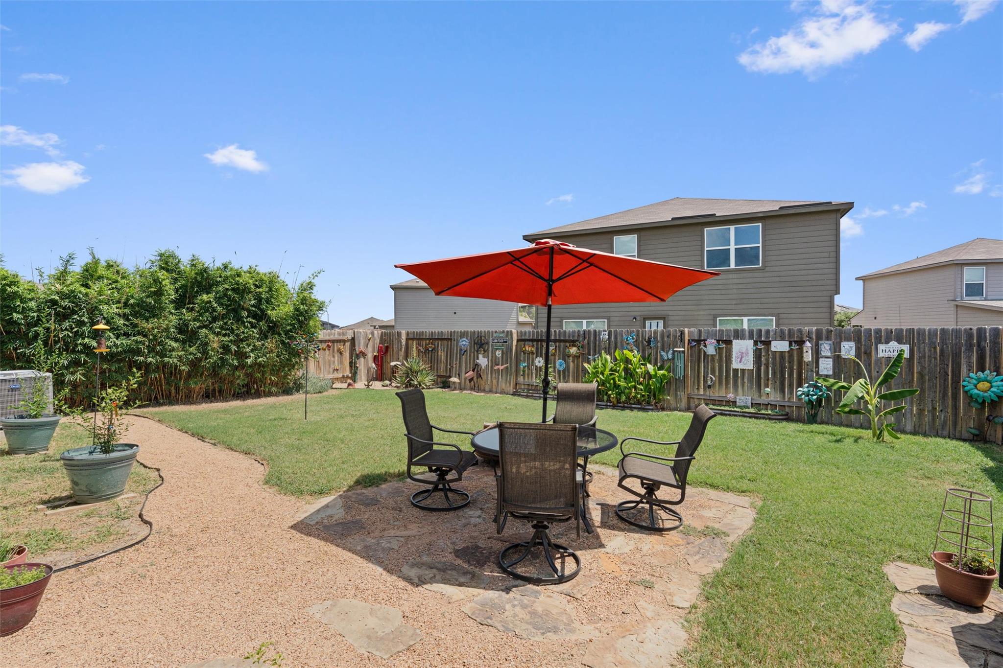 A flagstone patio with a vibrant red umbrella off