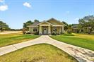 A gracefully curved driveway leads to a welcoming