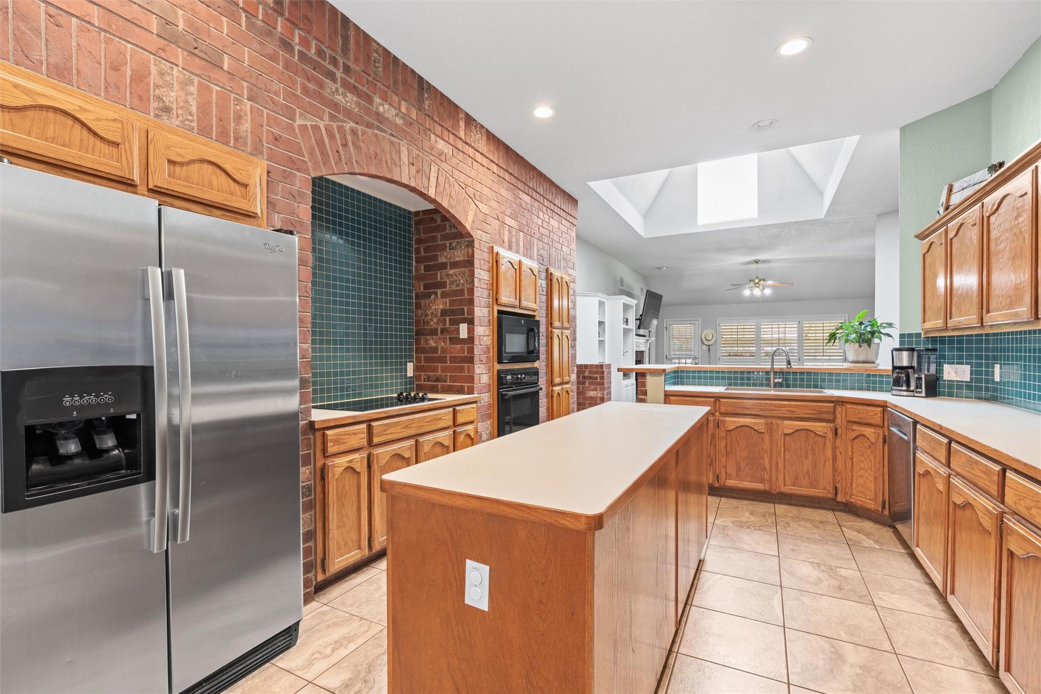 A spacious kitchen presents a large island, tile 