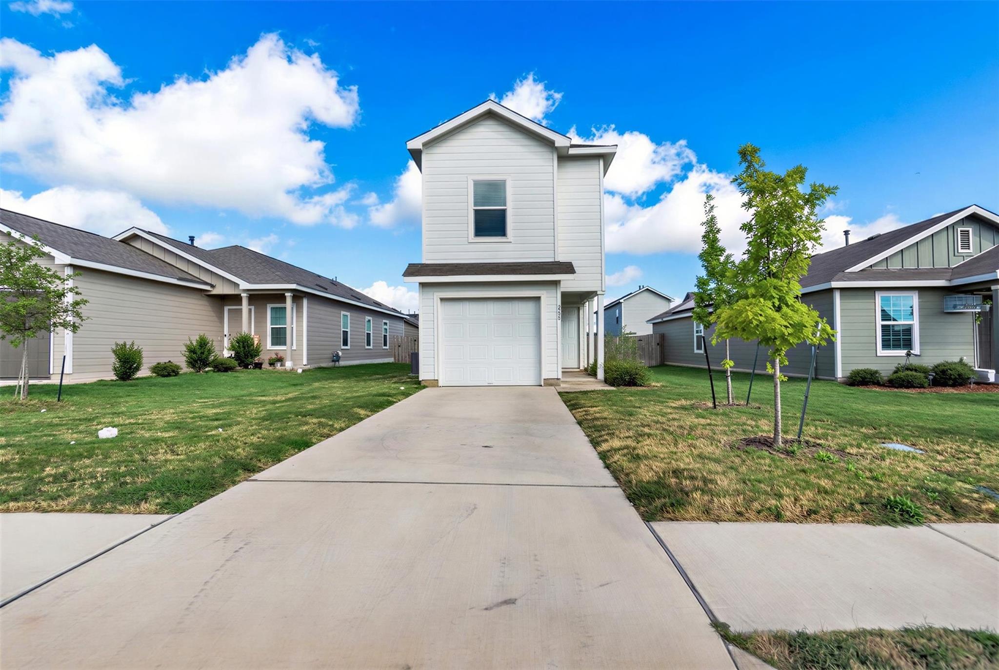 A concrete driveway leads to the attached single-