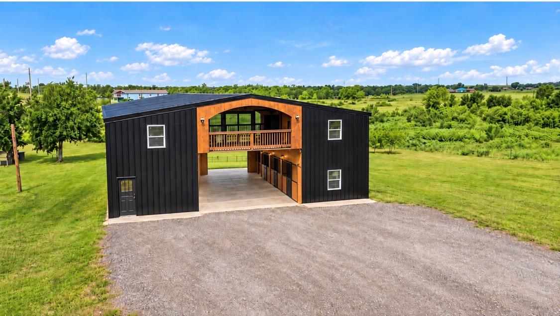 A modern metal barn features horse stalls and an 