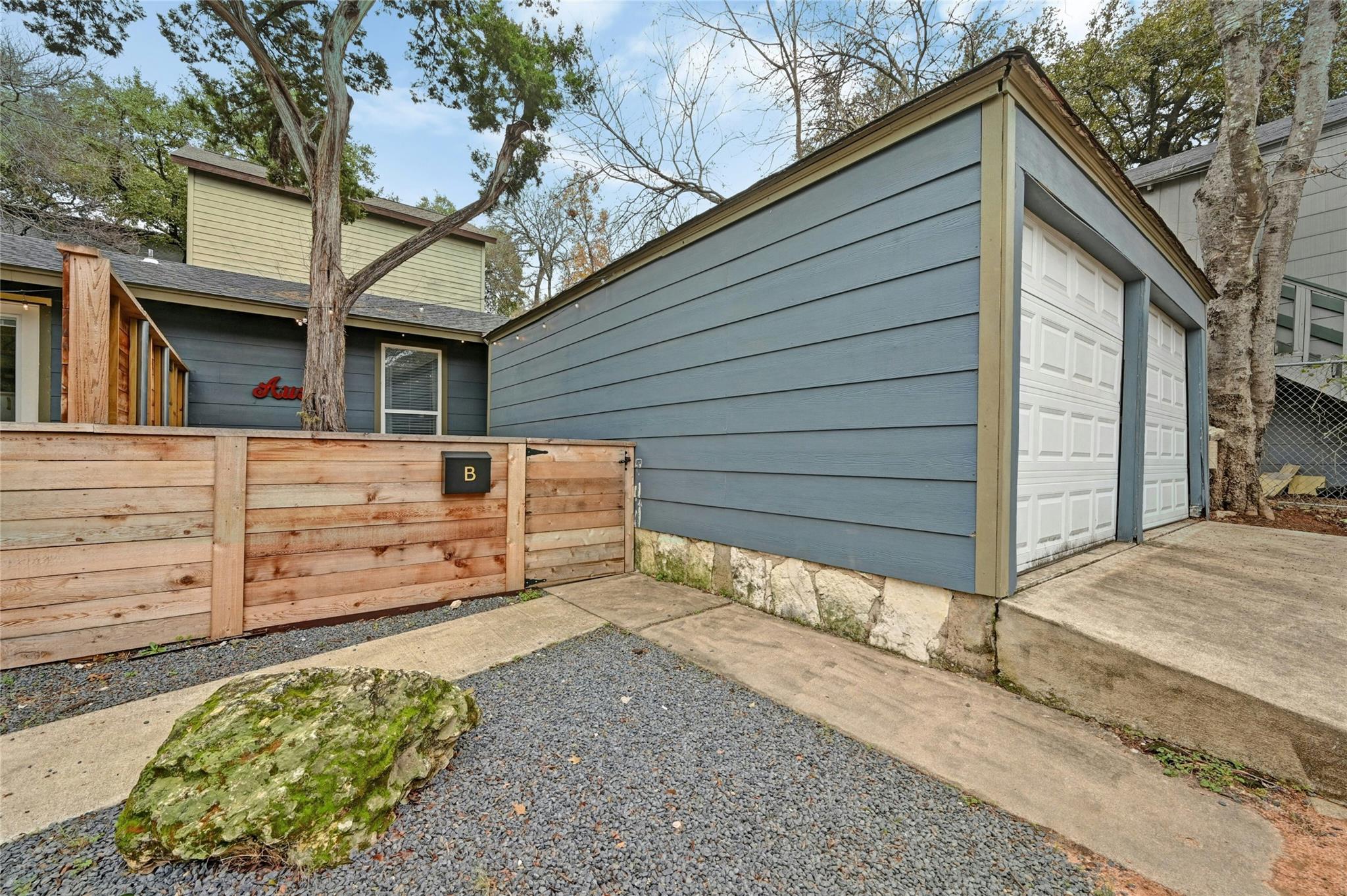 A welcoming wooden fence and gravel path lead to 