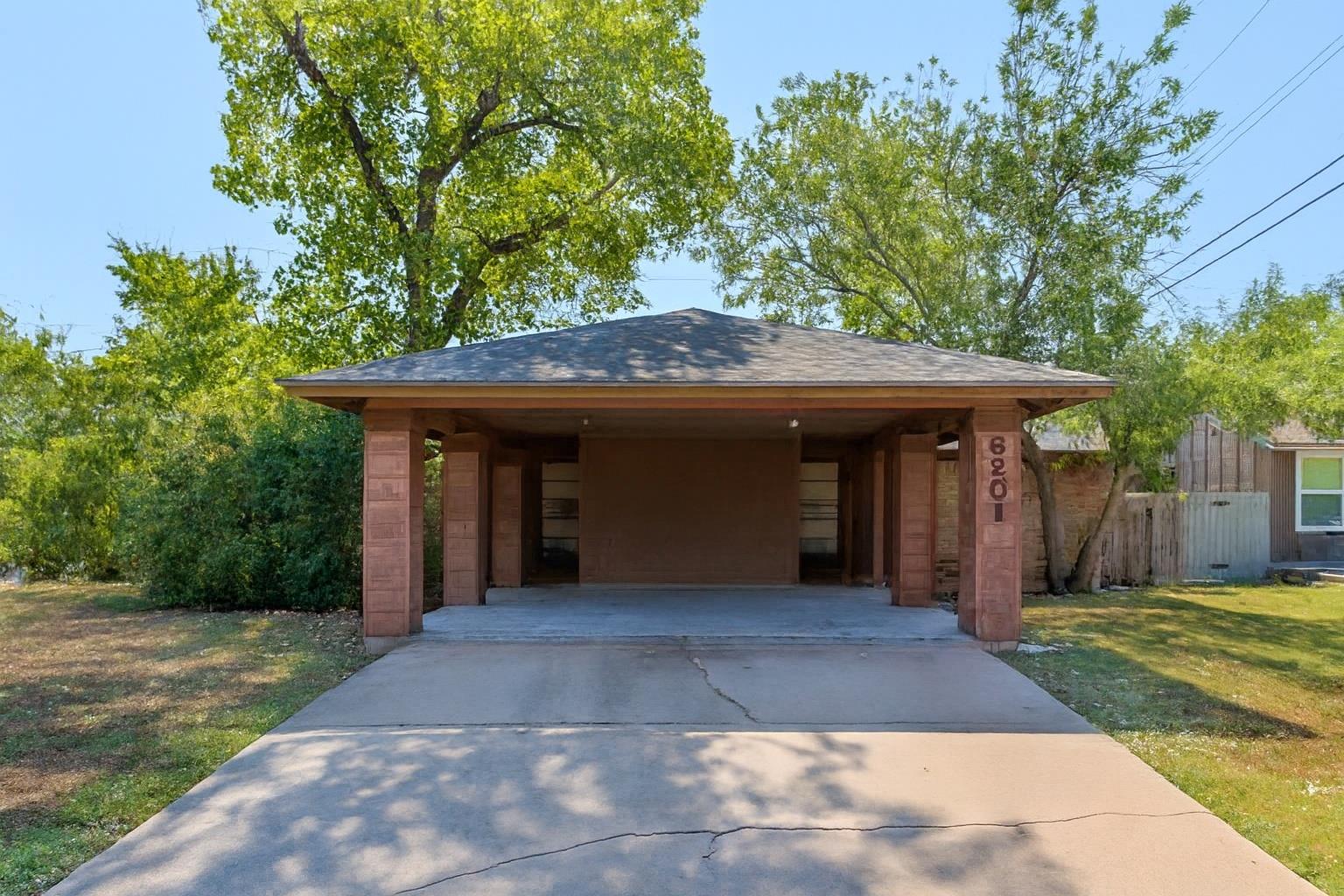A welcoming carport provides shelter and convenie