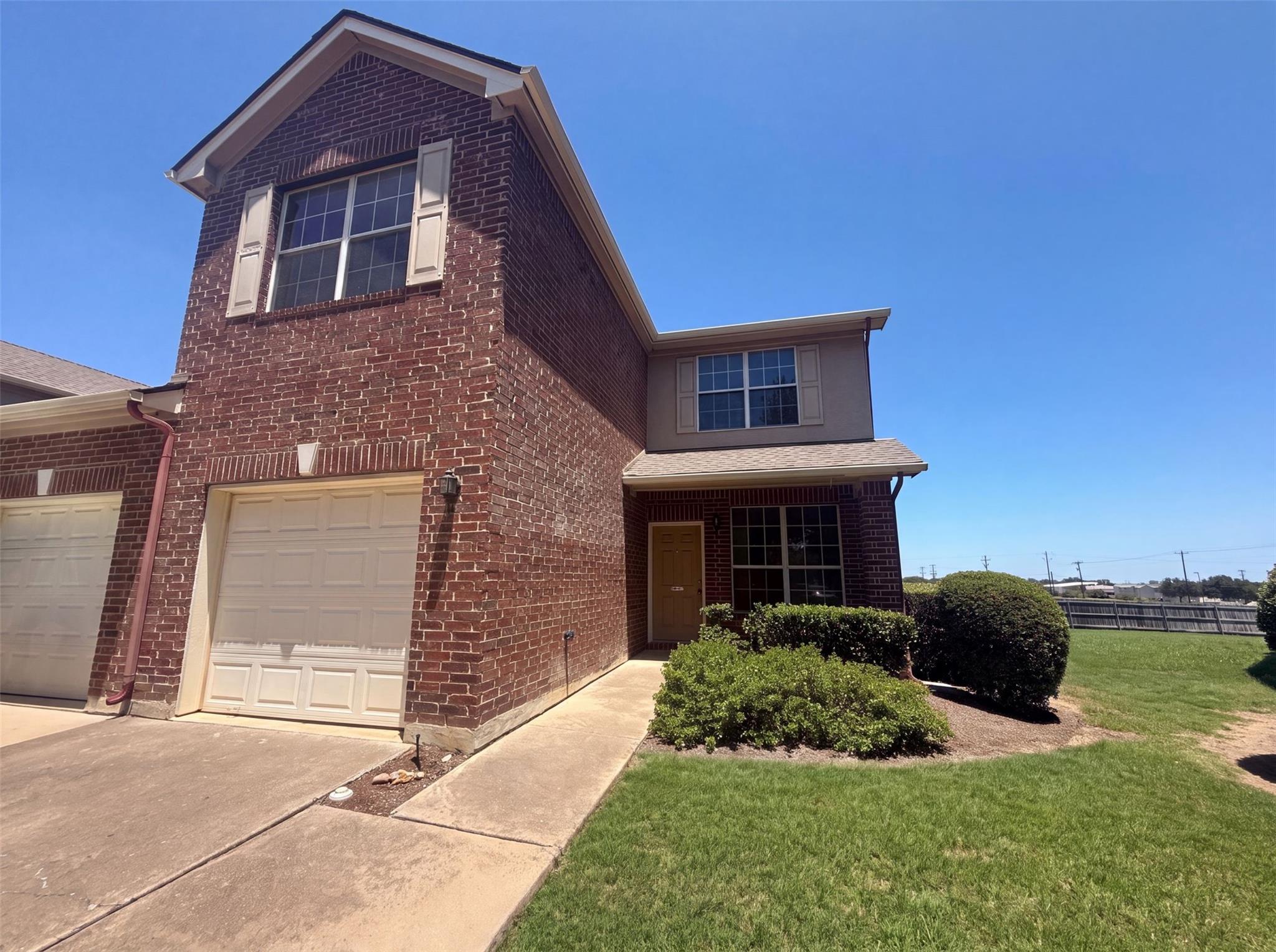 Brick exterior with attached garage and welcoming