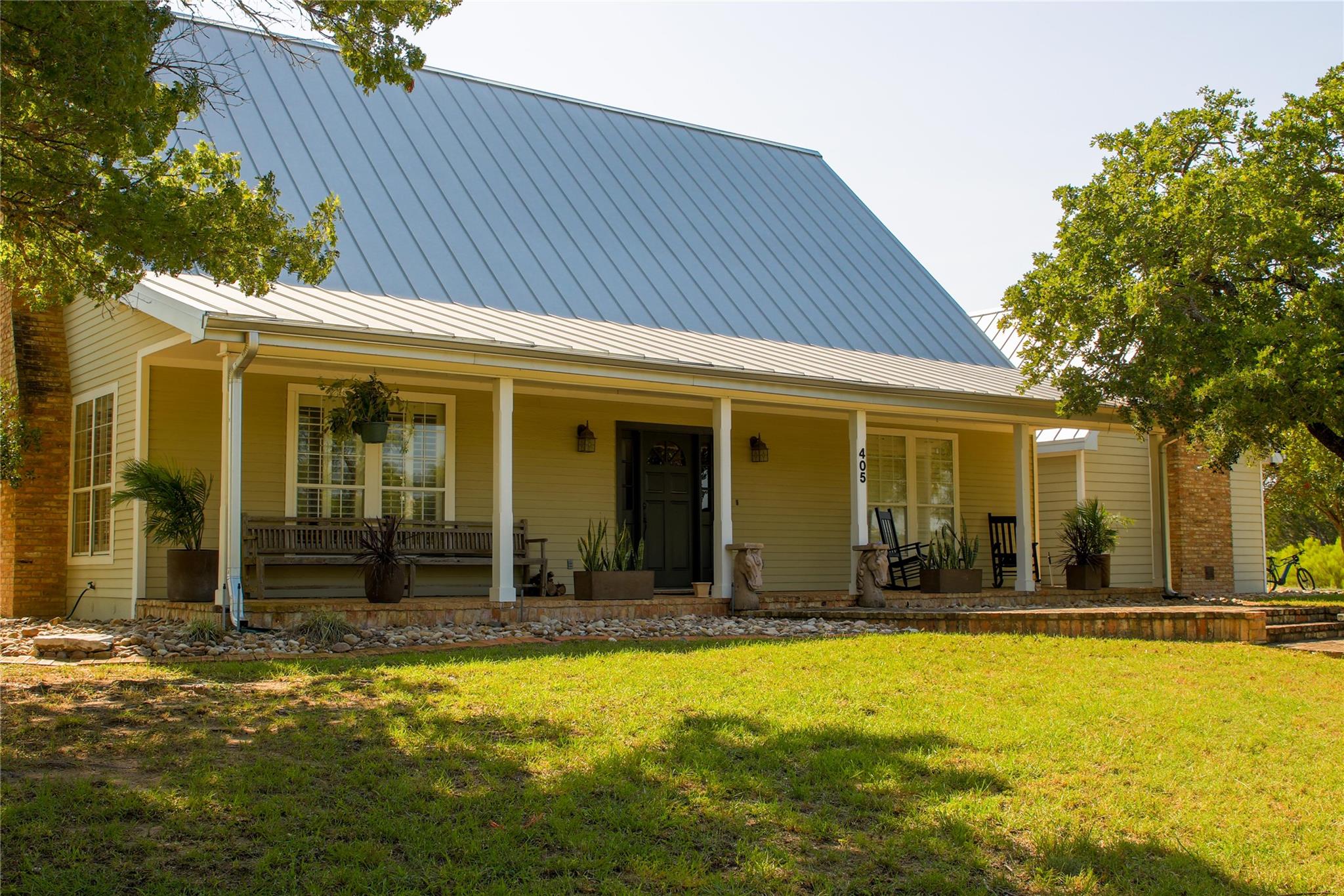 A welcoming front porch extends across the home, 