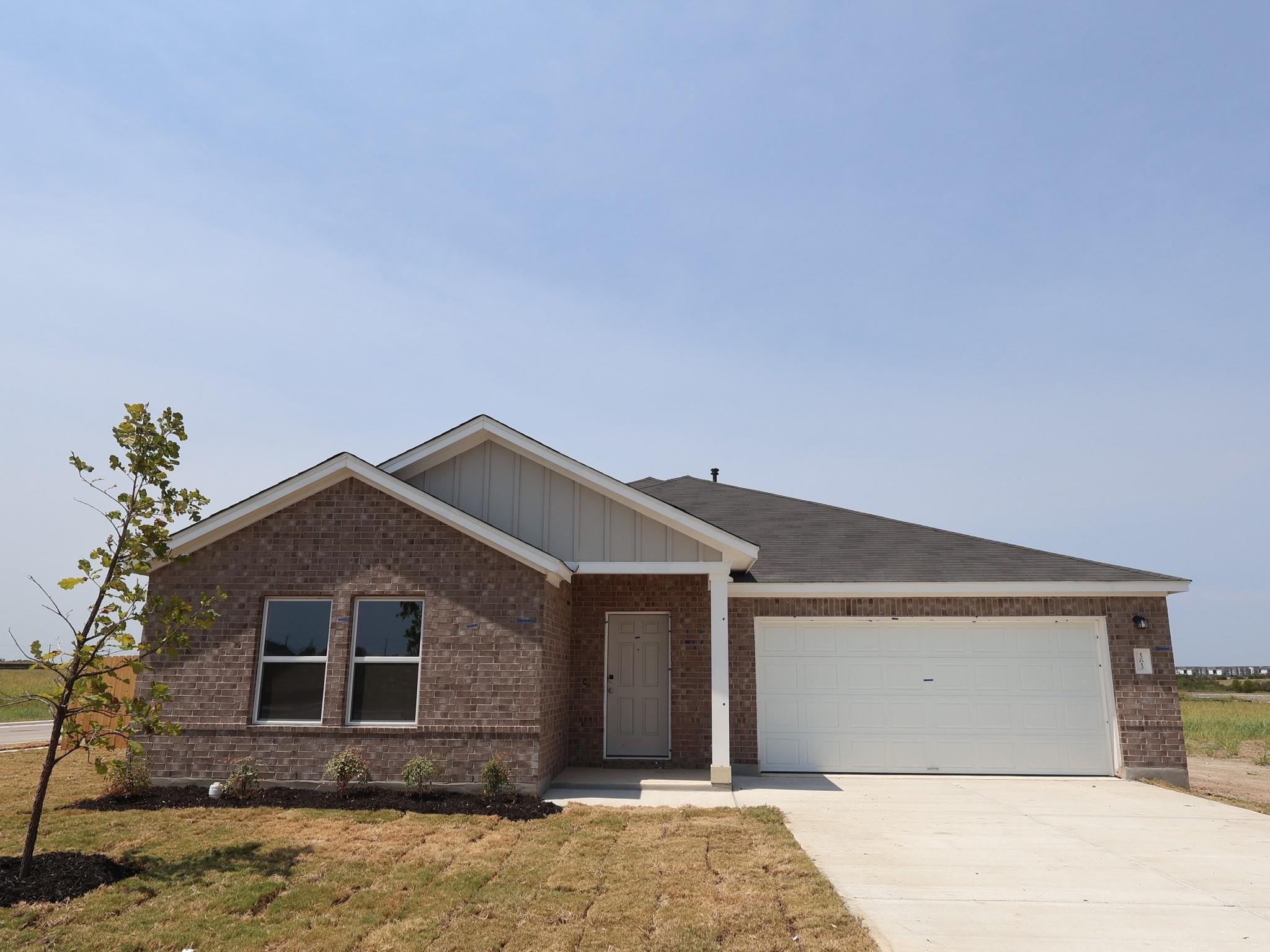 A classic brick exterior and concrete driveway de