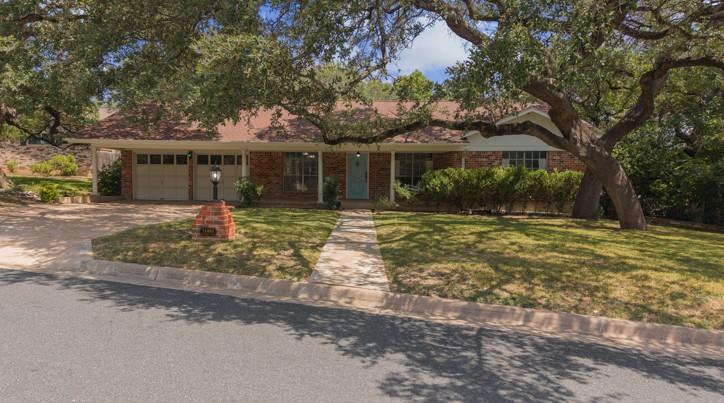 Mature trees shade a charming brick home, welcomi