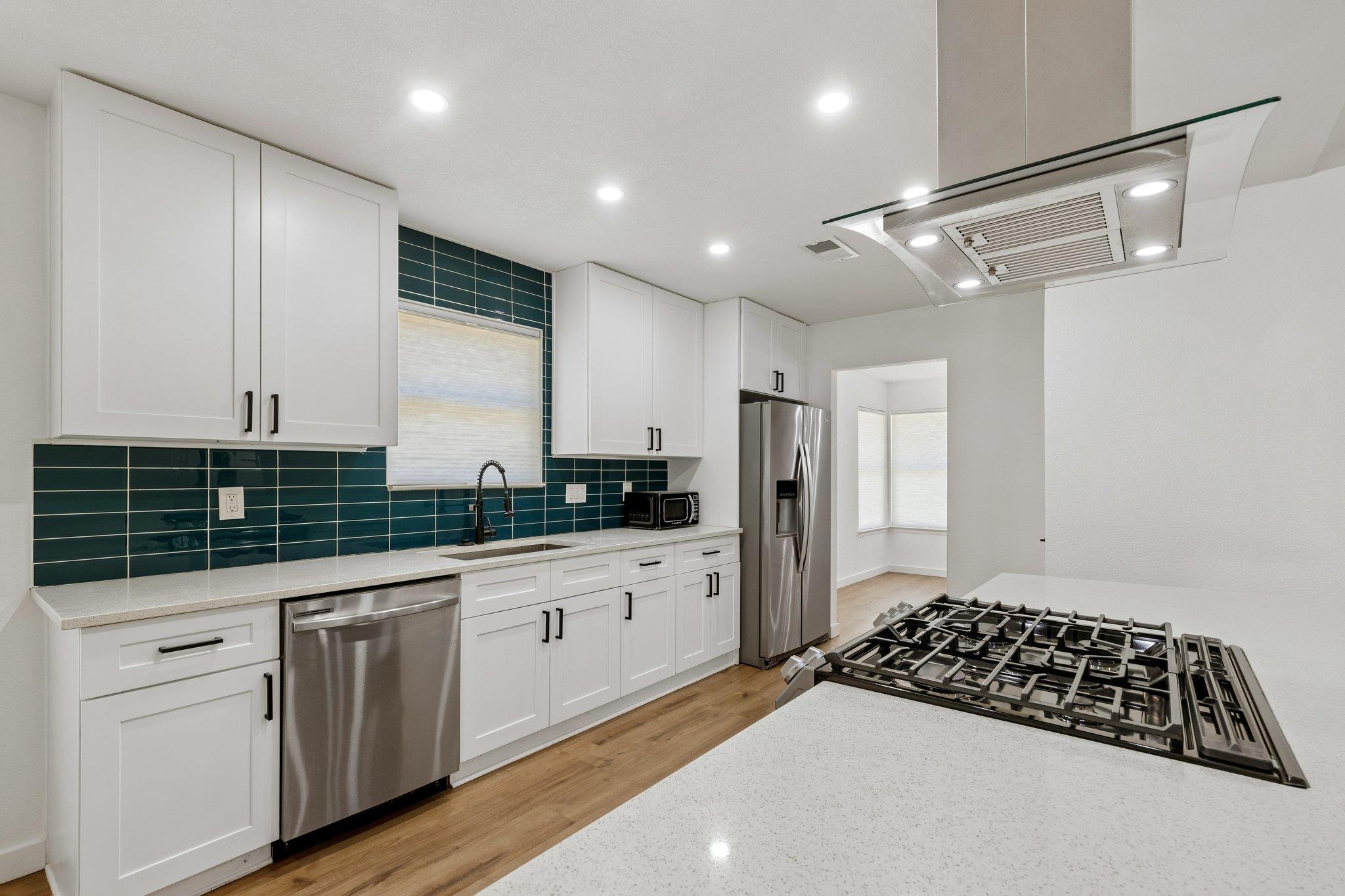 Warm wood-toned floors anchor clean white cabinet