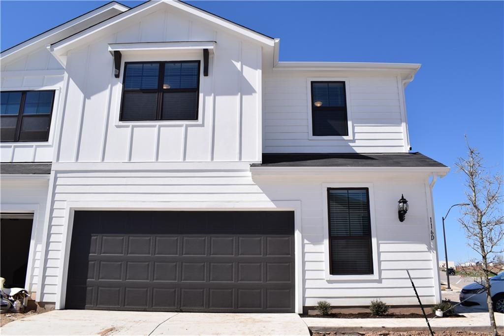 The striking white siding and dark garage door cr