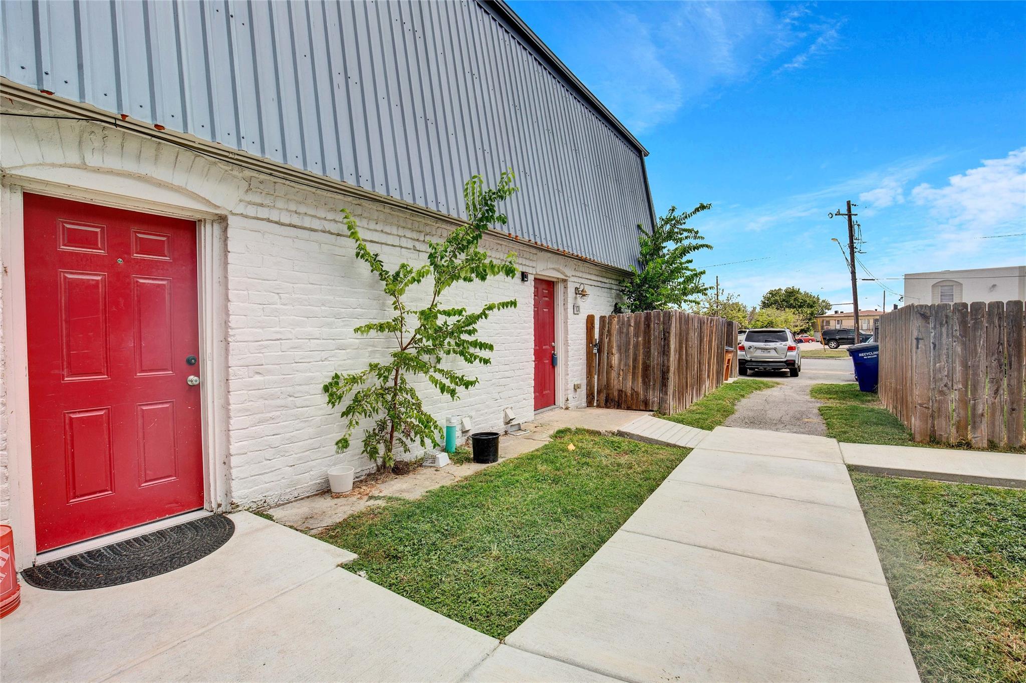 Concrete pathways lead to vibrant red entry doors
