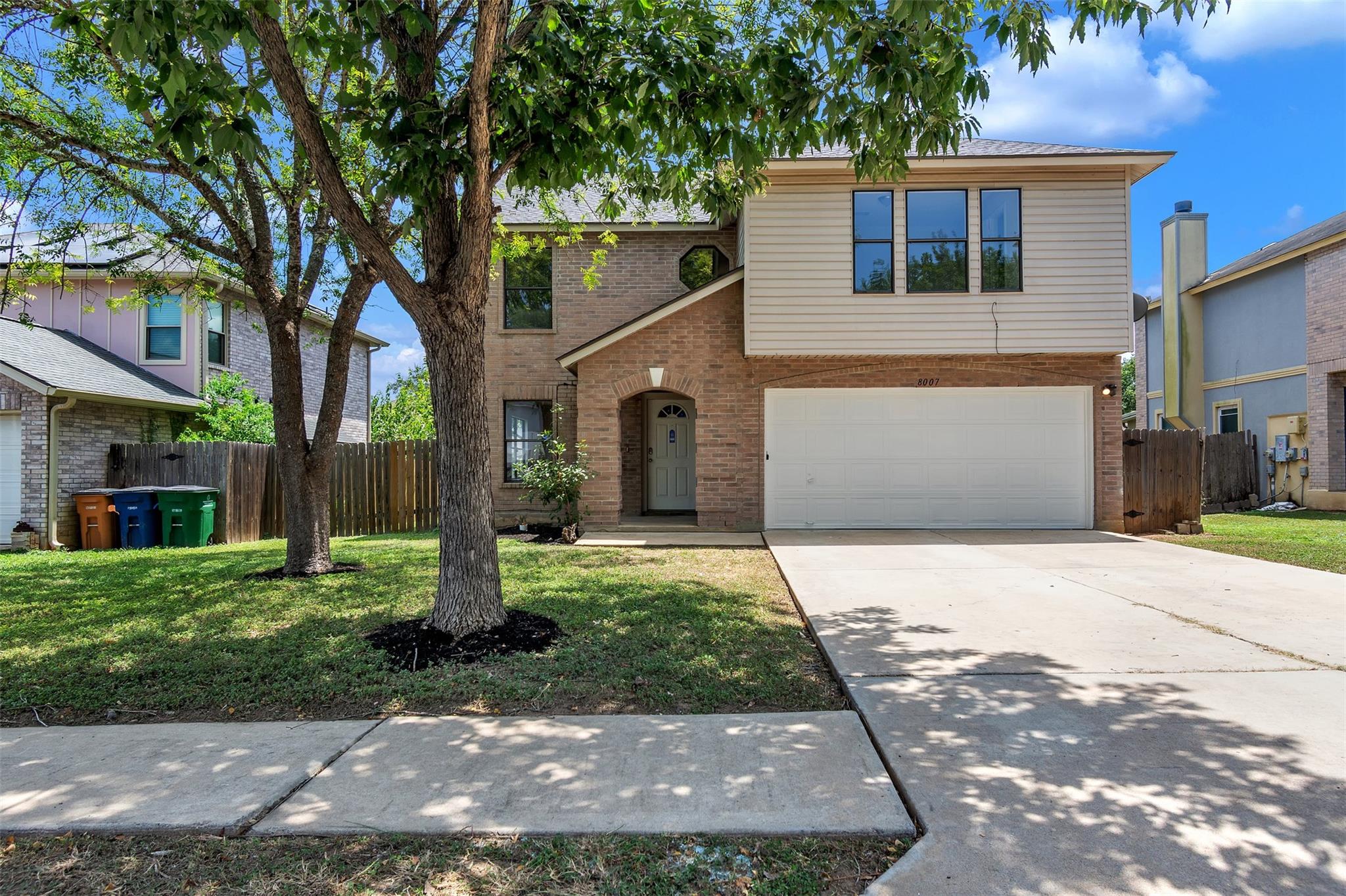 A classic brick and siding home presents a welcom