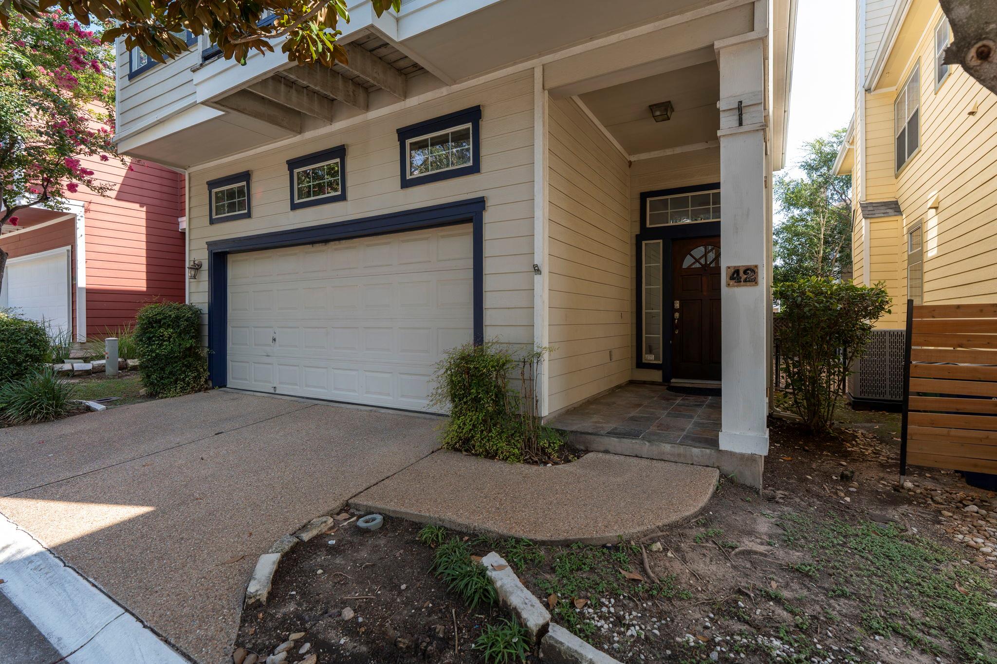 A welcoming entry features a paneled garage door 