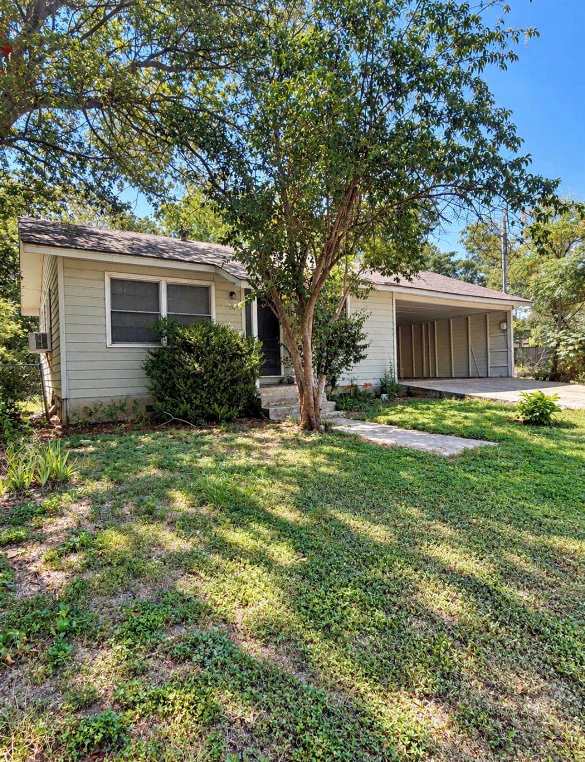 Mature trees shade a classic single-story home fe