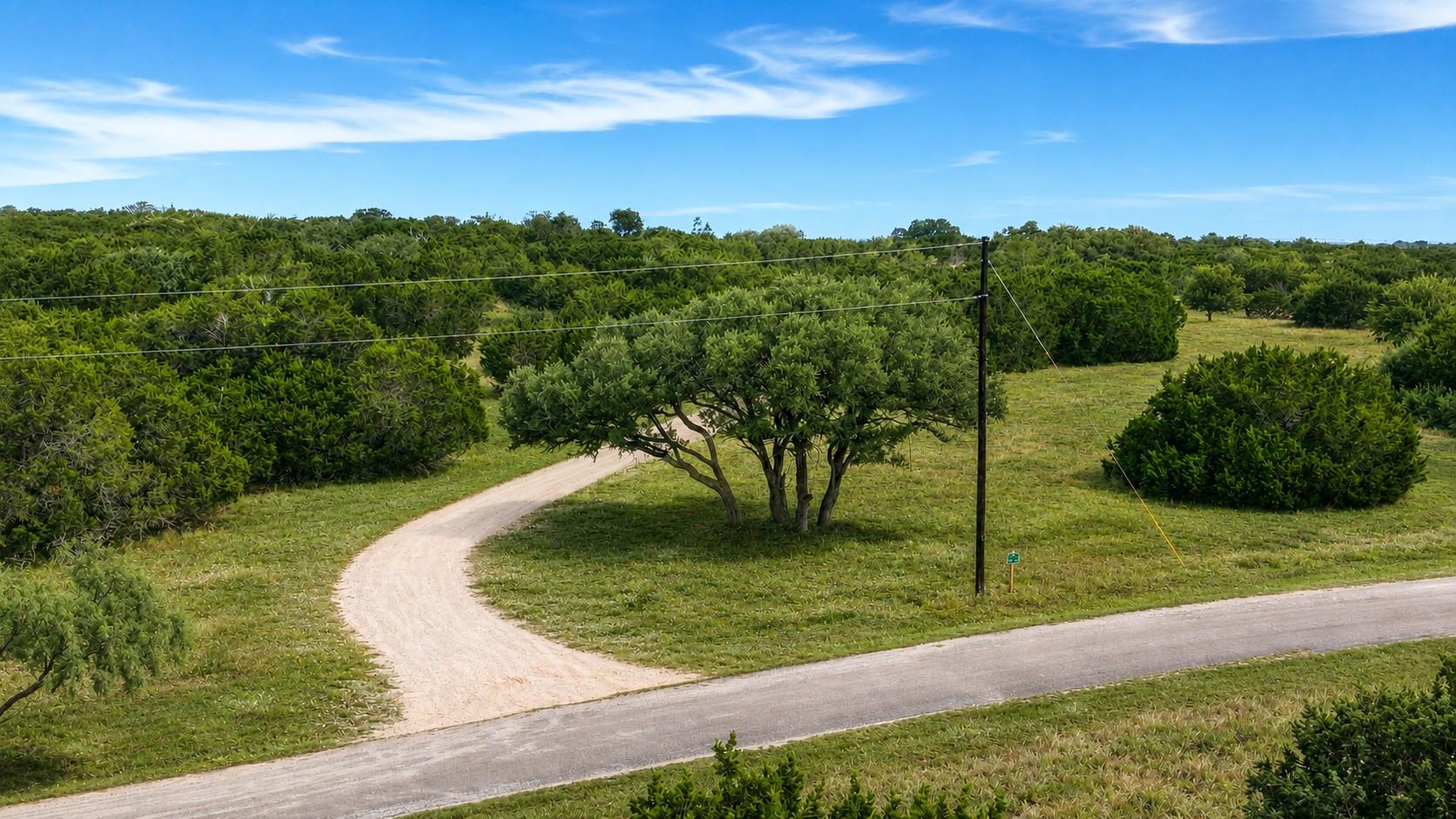 A winding gravel drive leads through lush, verdan