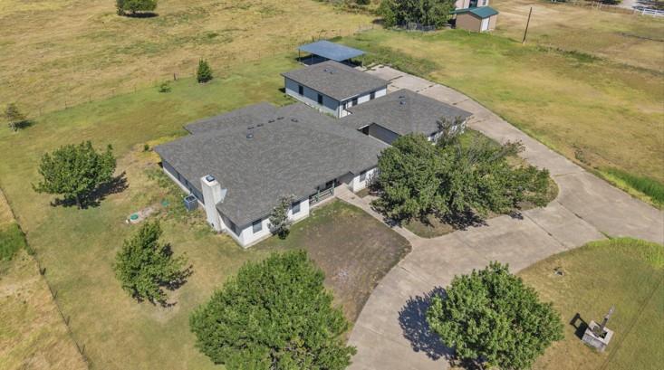 A spacious rural property features shingle roofs 