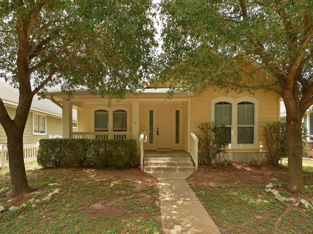 A welcoming yellow bungalow features a covered fr
