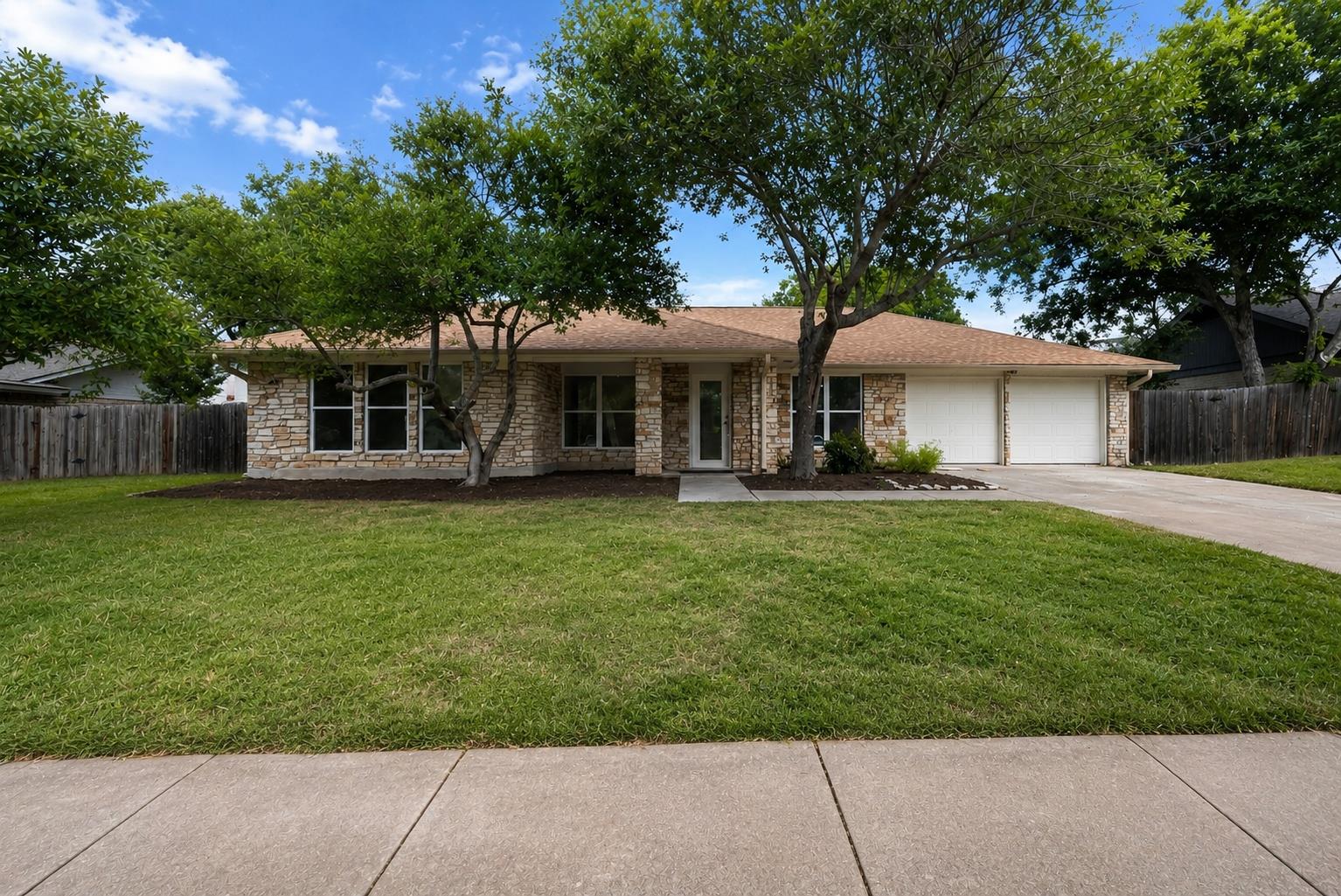 A welcoming stone facade with a neatly kept lawn 