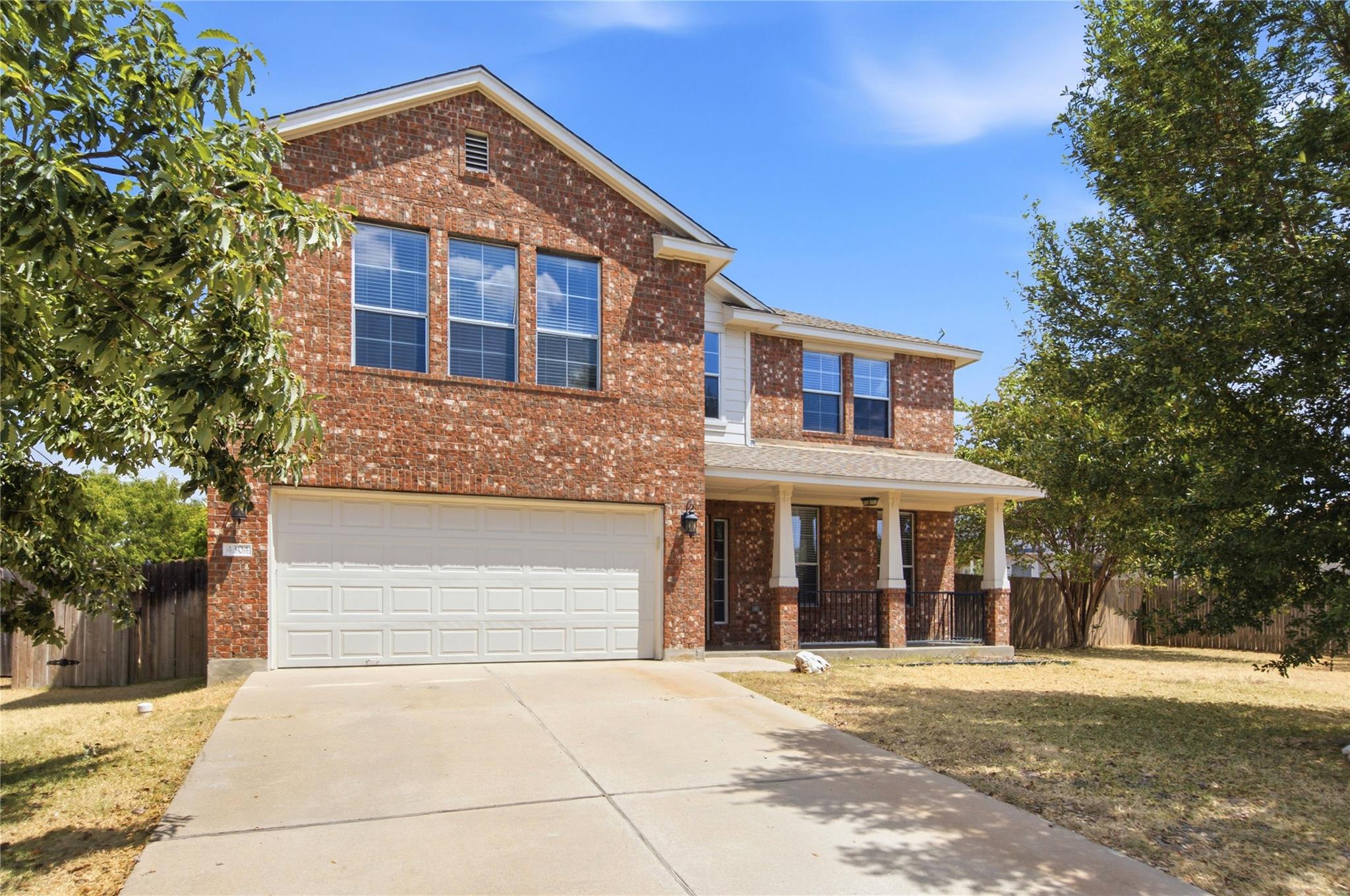 A spacious concrete driveway leads to a two-story