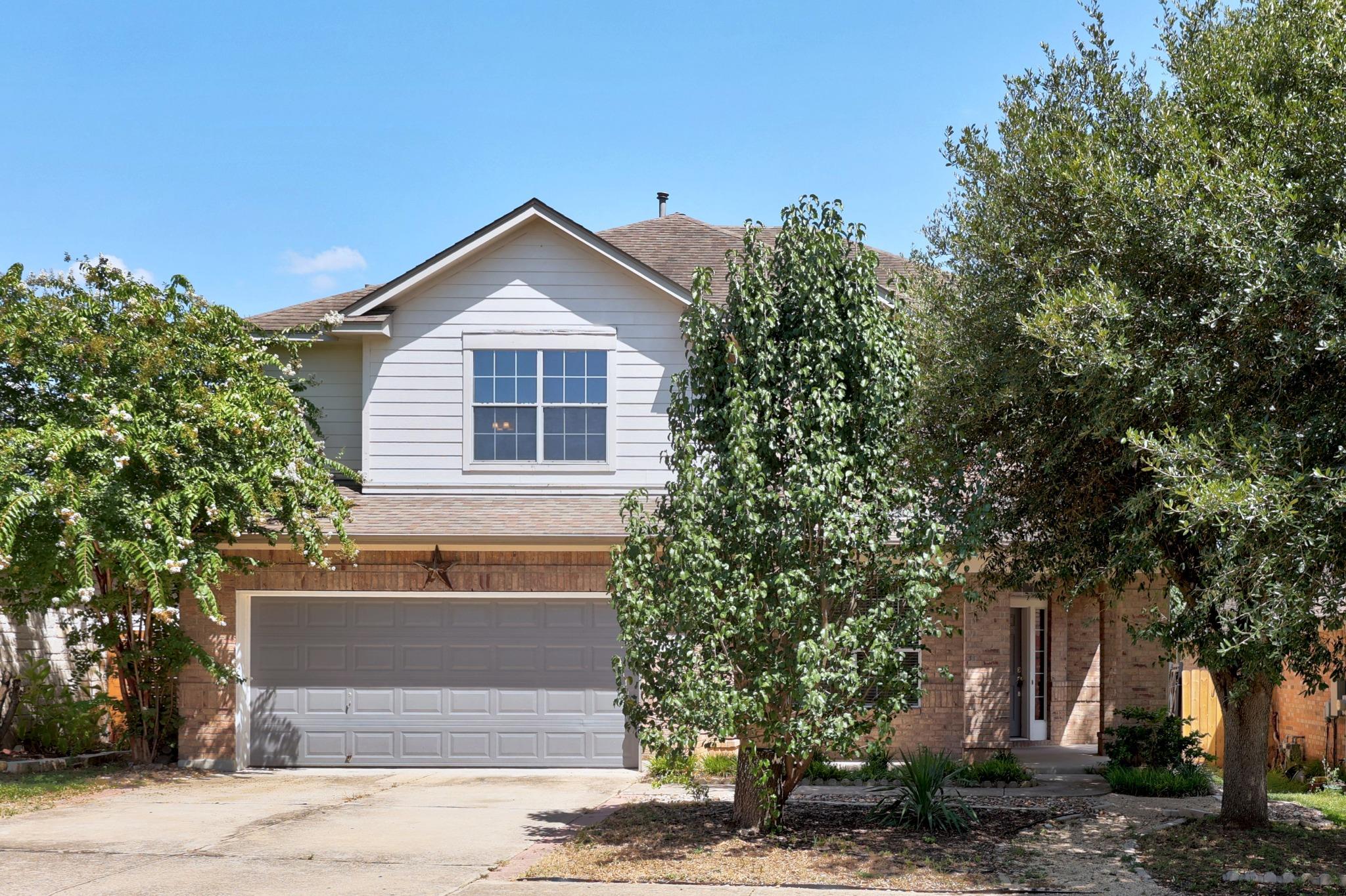 A classic brick and siding home presents a welcom