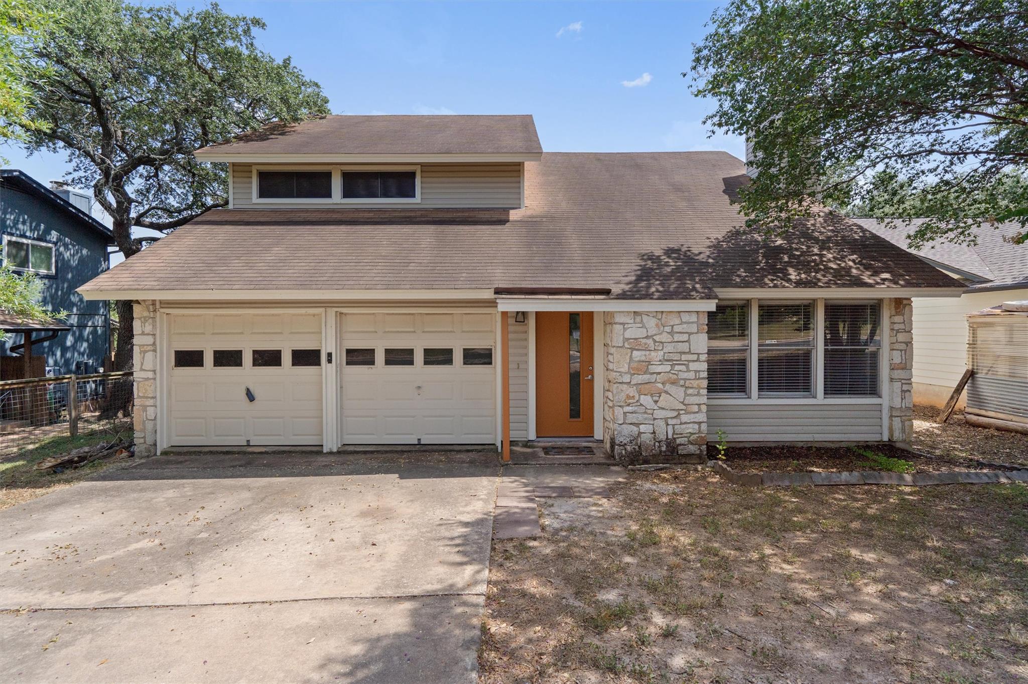 A traditional home featuring a two-car garage, wa