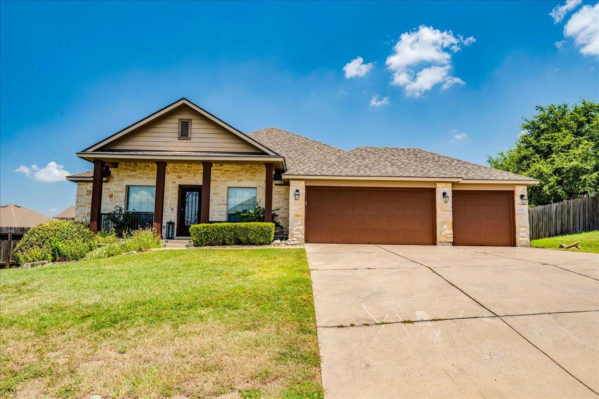A welcoming stone facade home features a columned
