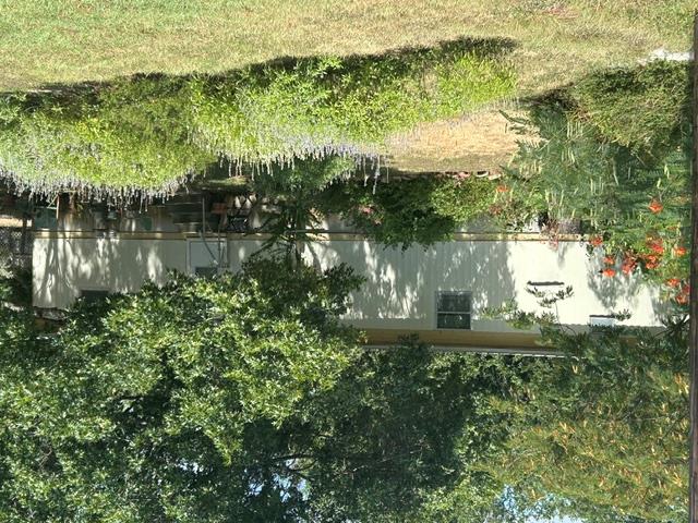 Mature trees and lush landscaping frame this invi