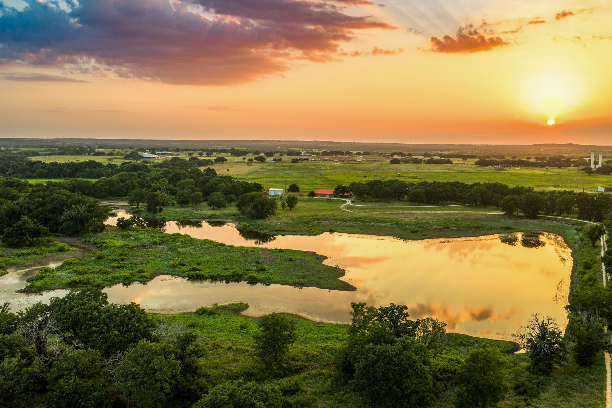 Golden hour illuminates a tranquil lake and verda
