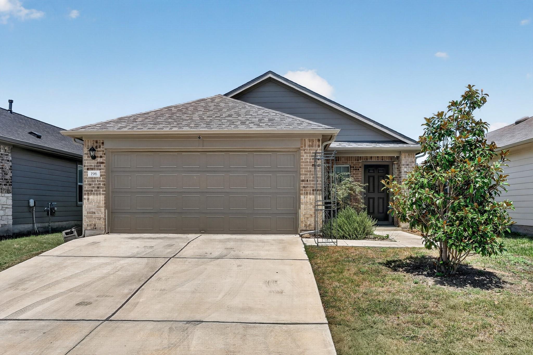 A welcoming facade showcases brick and siding acc