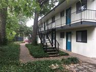 Mature trees frame the exterior walkways and stru