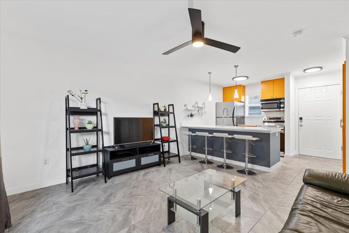 Living room with ceiling fan and baseboards