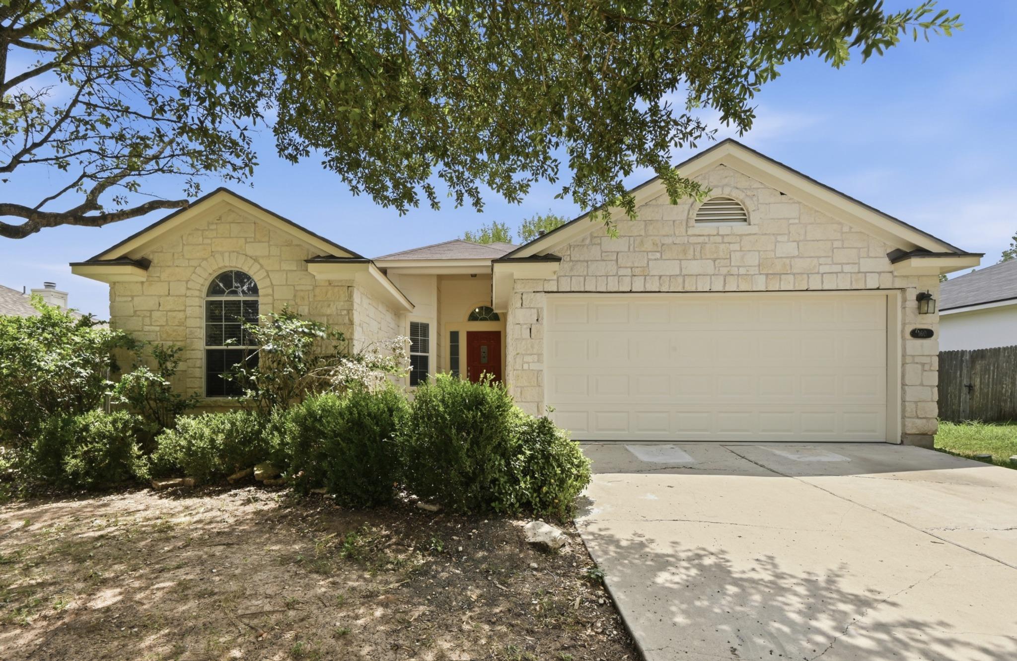 A cream brick facade and a wide driveway lead to 