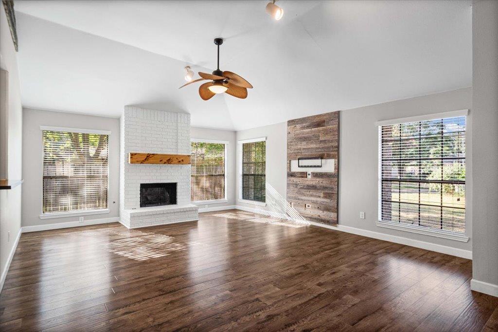 A generous living space featuring a white brick f