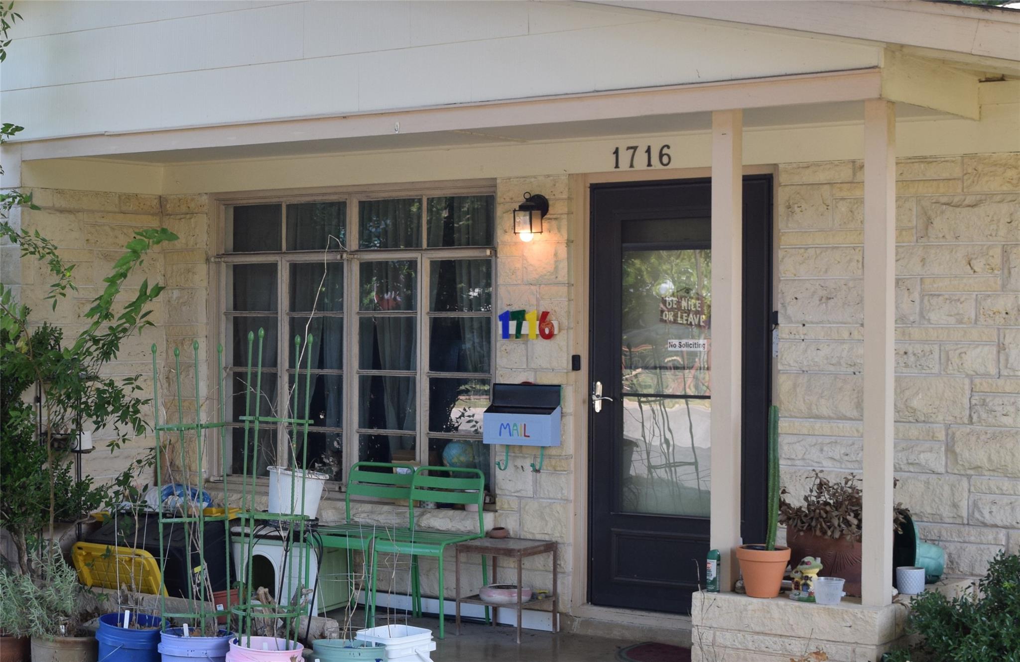 A welcoming front porch features stone constructi
