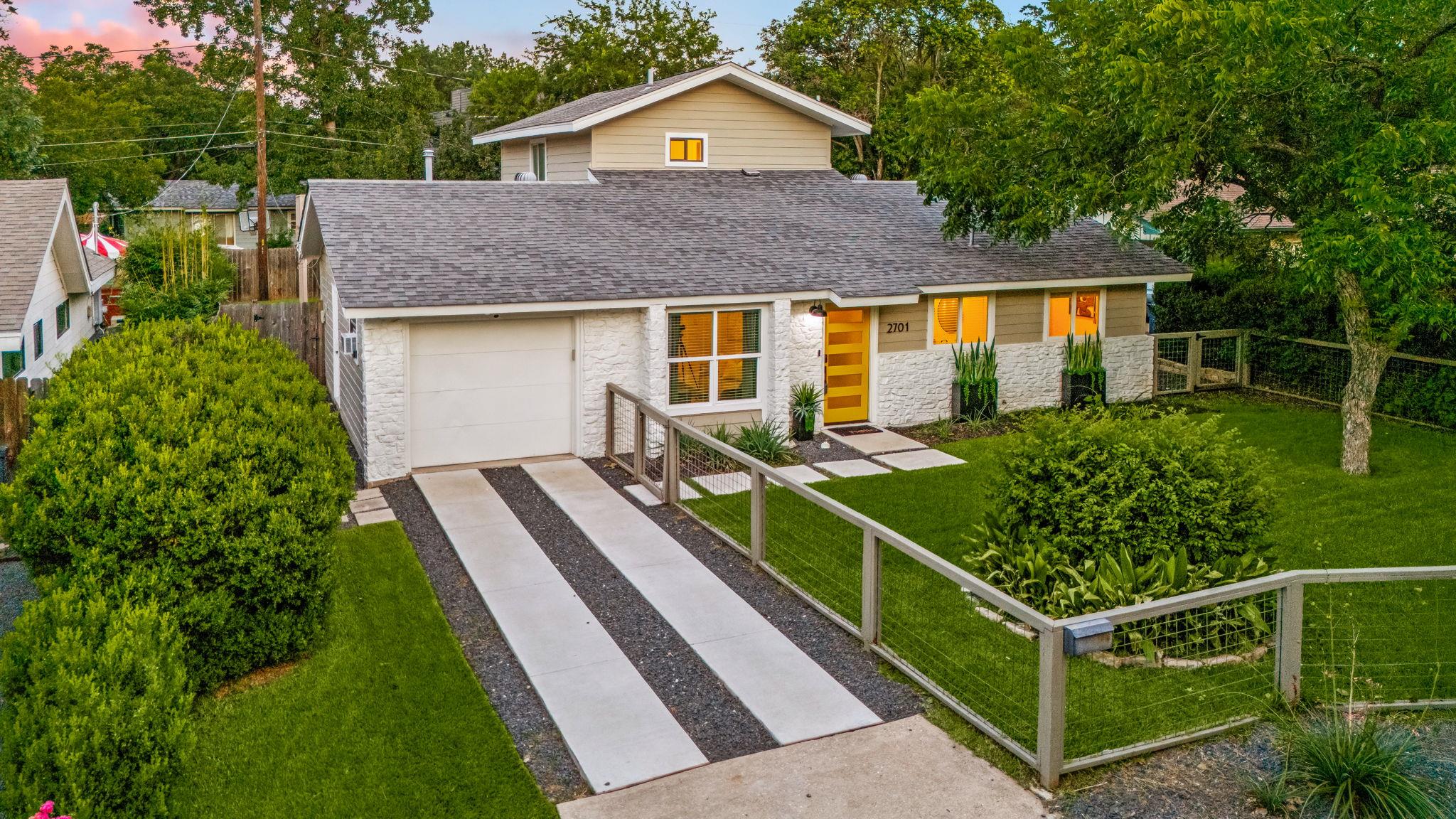 Mature trees frame a modern multi-level exterior 