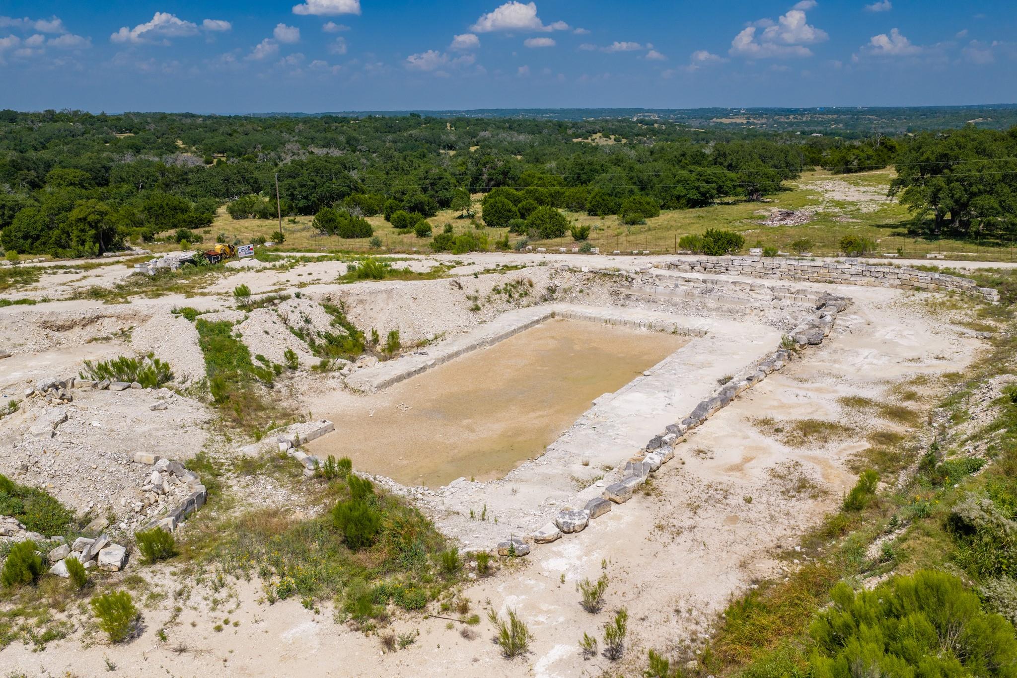 A partially excavated pool foundation awaits deve