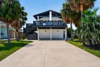 Palm trees frame a wide concrete driveway leading
