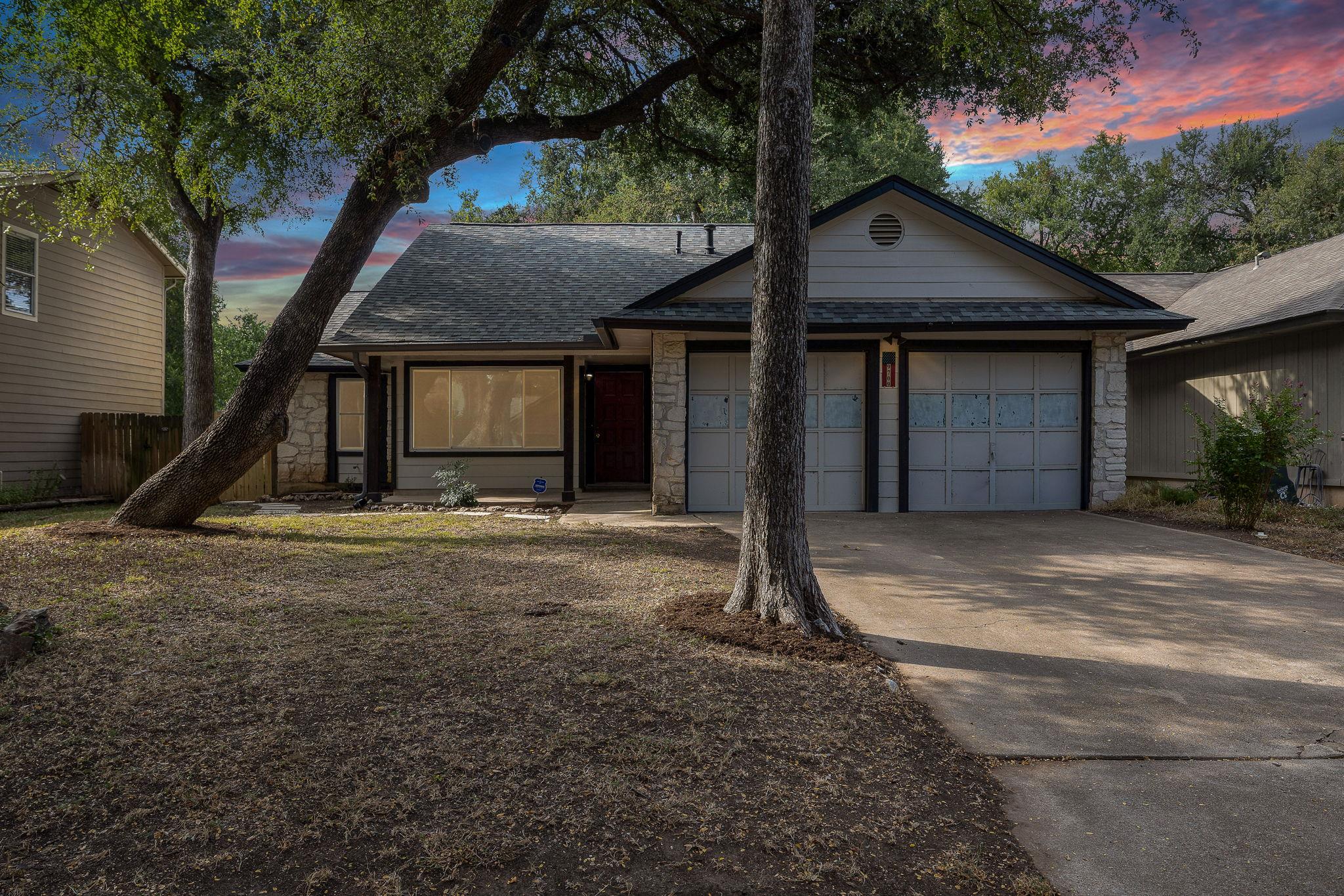 Mature trees shade this inviting residence, featu