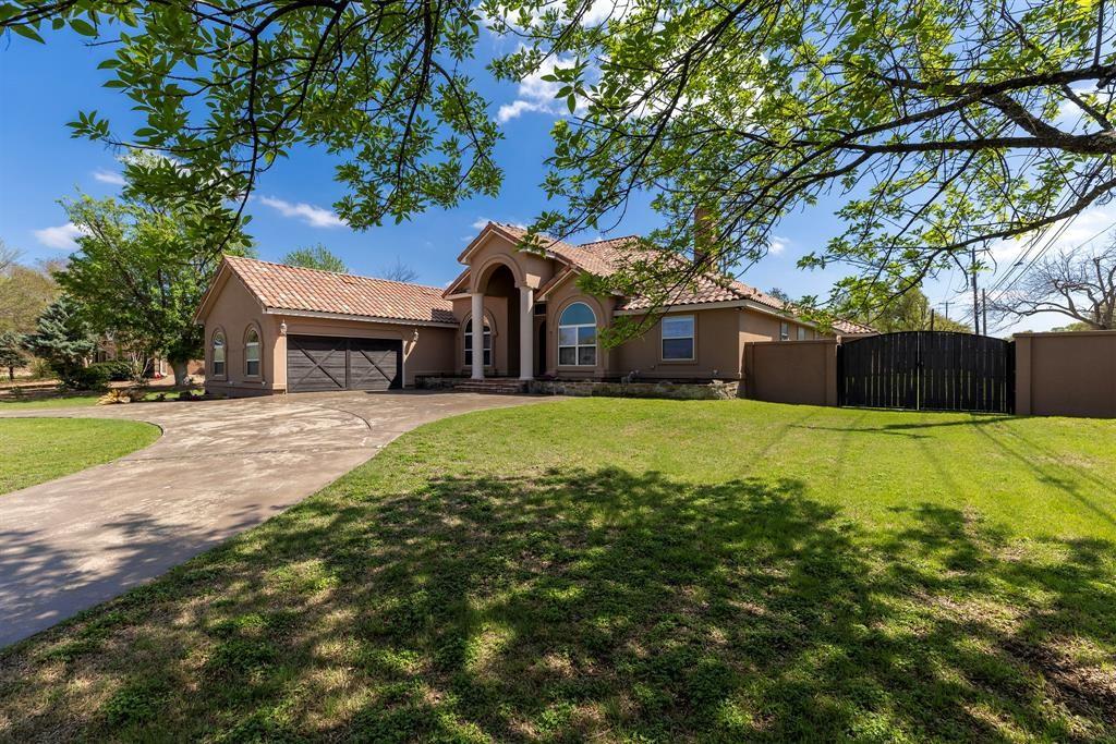 A spacious driveway gracefully approaches this in