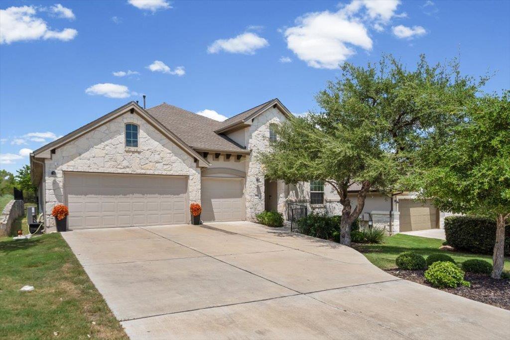 A well-maintained concrete driveway leads to a st