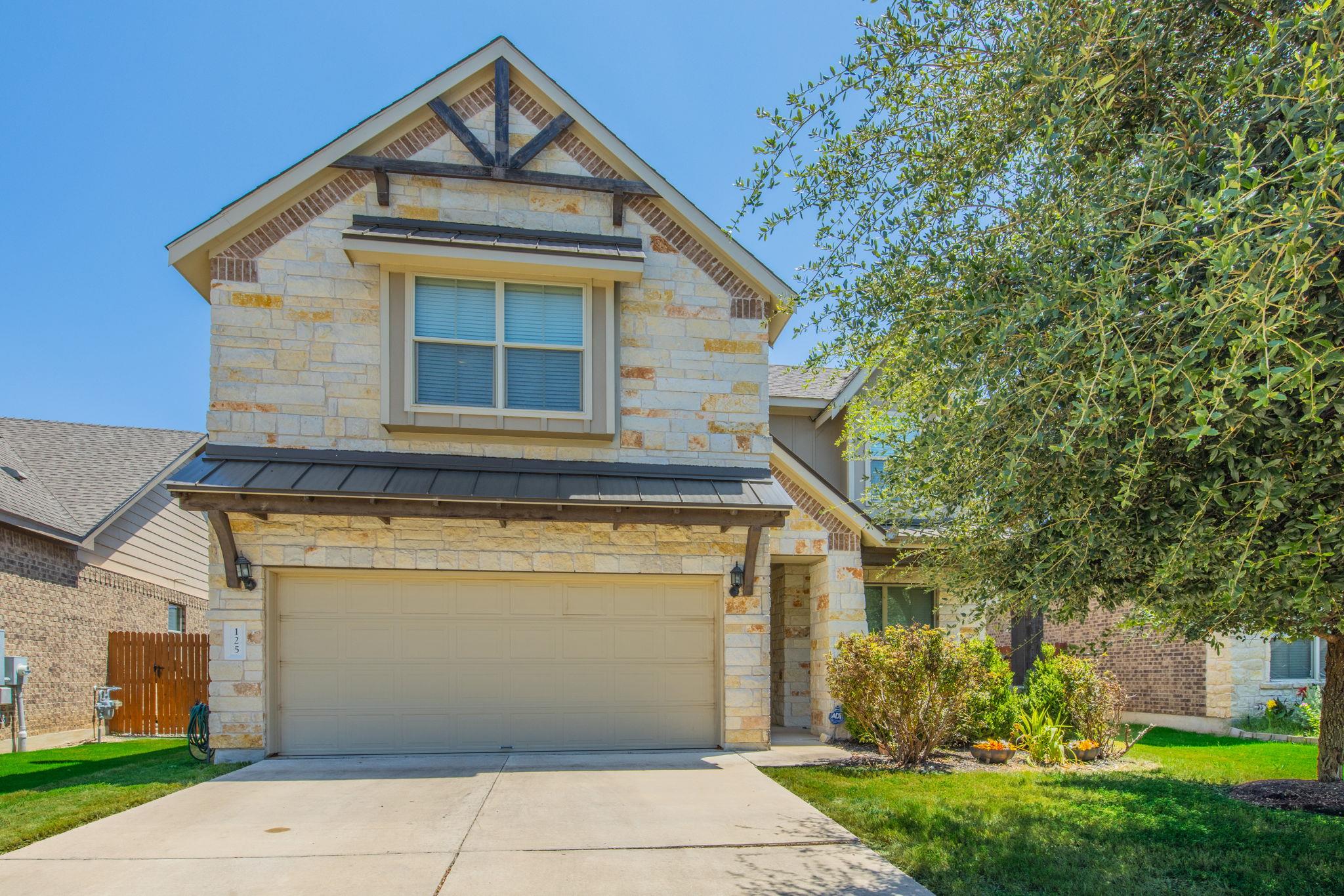 A welcoming stone and brick facade with a two-car
