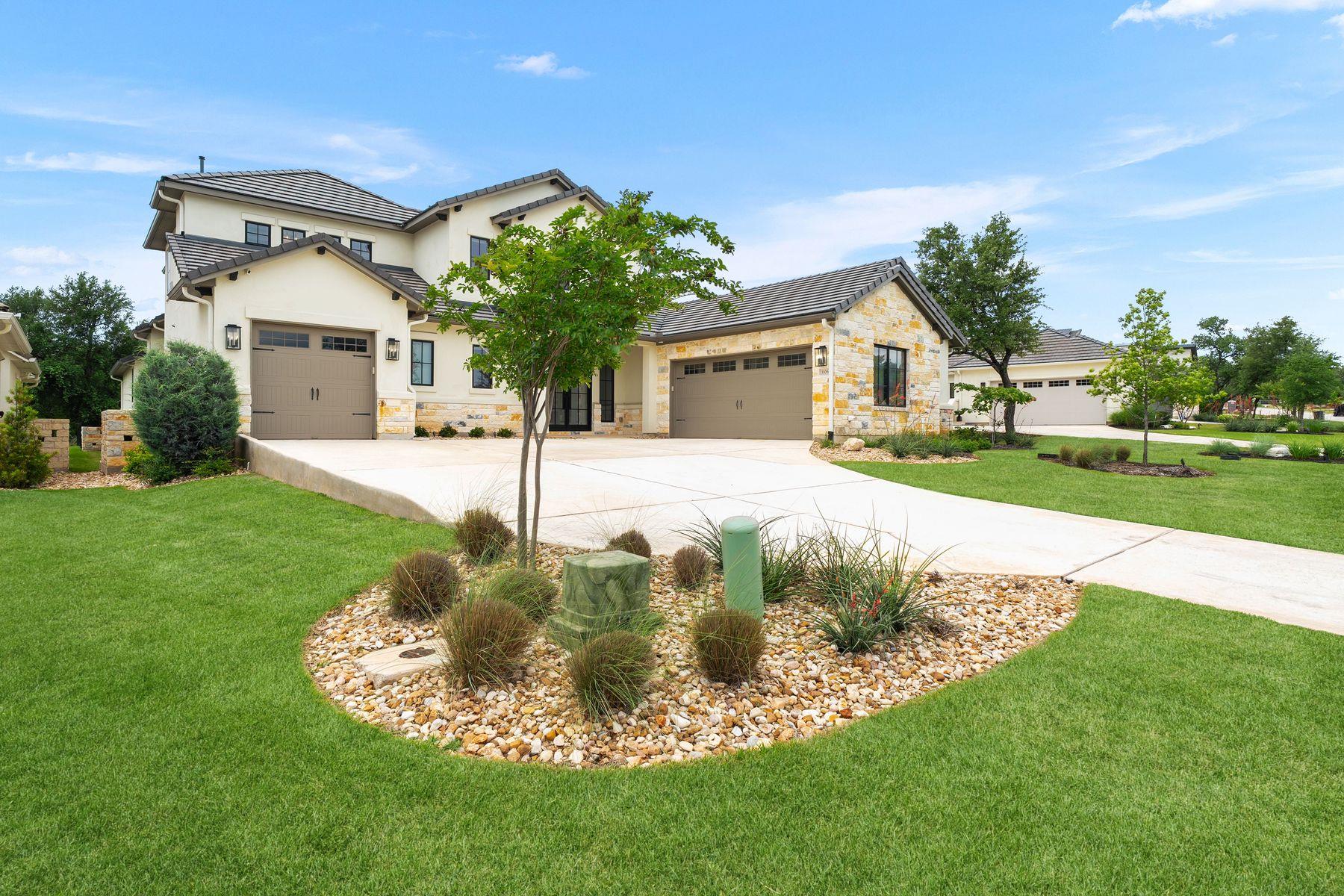 A graceful paved driveway winds through lush, wel