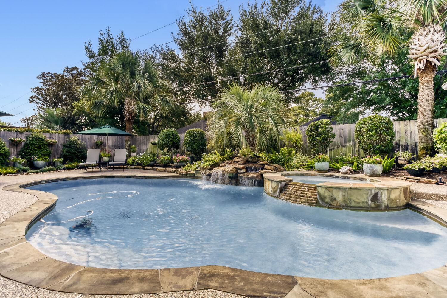 A tranquil backyard oasis features a freeform poo