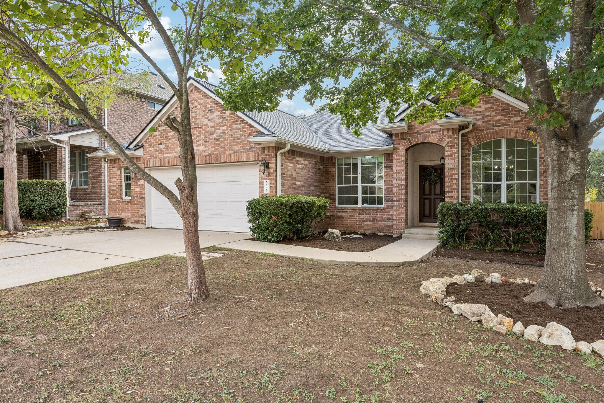 Mature trees frame a classic brick exterior with 