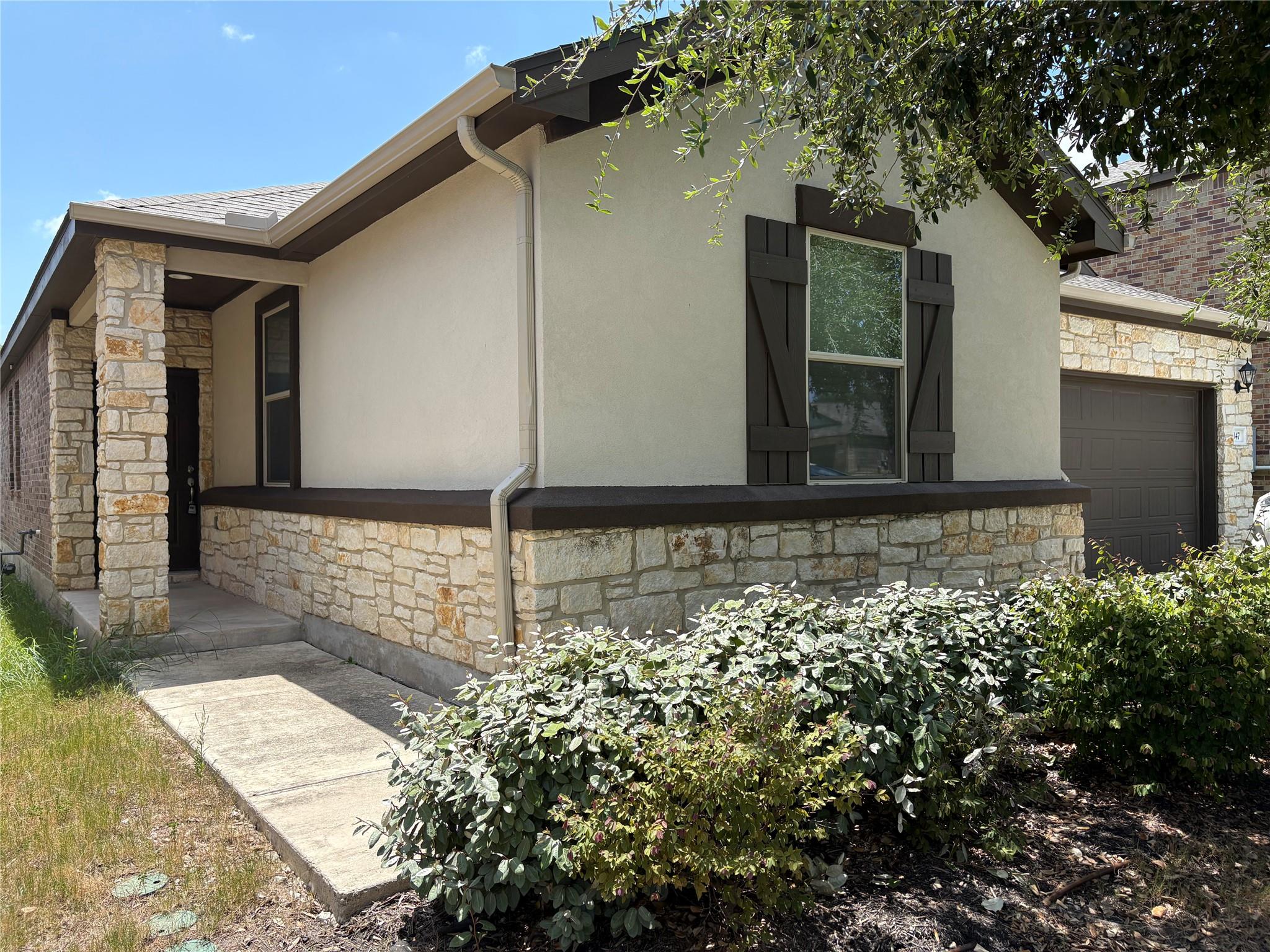 A welcoming façade boasts a stone and stucco exte